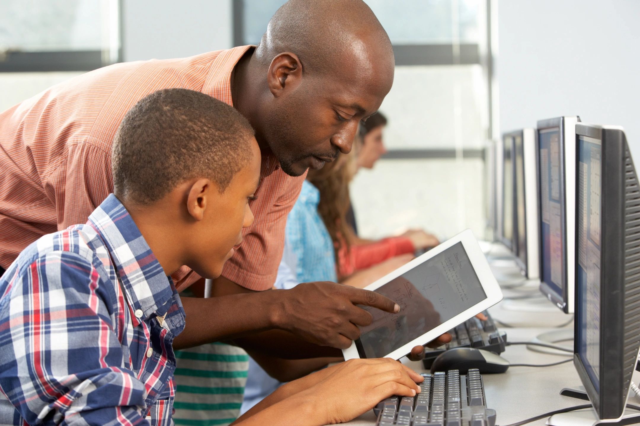 A man and boy looking at an ipad